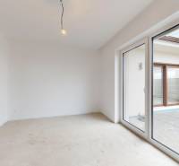 Innenraum eines Einfamilienhauses mit Ausgang zur Terrasse und nicht verlegtem Boden.