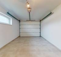 Garage in einem Einfamilienhaus mit einem großen Eingangstor und einem Fenster an der Seitenwand.