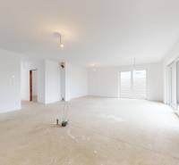 Das Innere eines Einfamilienhauses mit weißen Wänden und großen Fenstern, der Boden ist bereit für Anpassungen.