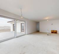 Einfamilienhaus mit geräumigem Wohnzimmer, großem Fenster und Blick auf die Terrasse.