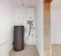 Heizung und Boiler im Technikraum eines Einfamilienhauses mit Fliesenboden.