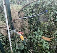 Nitra, Gärten: Gartenschlauch und Wasserhahn in überwucherter Umgebung.