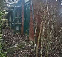 Eine Hütte in den Gärten von Nitra, umgeben von winterlicher Natur mit kahlen Ästen.