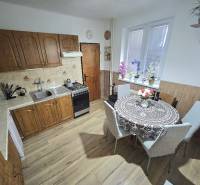 Küche in einem Einfamilienhaus mit Holzdekor, mit Esstisch und Küchenzeile.