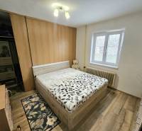 Schlafzimmer mit Bett und Holzboden in einem Einfamilienhaus.