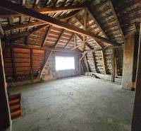 Dachboden eines Einfamilienhauses mit freiliegender Dachkonstruktion und Treppe.