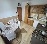 Küche in einem Einfamilienhaus mit Holzelementen und Esstisch.