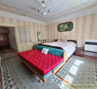 Schlafzimmer im Einfamilienhaus mit Doppelbett, Sofa und gemusterten Teppichen.