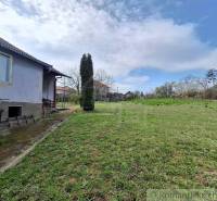 Ein Einfamilienhaus in Ľuba mit einem geräumigen Hof und grünem Rasen unter blauem Himmel.