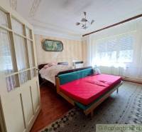 Schlafzimmer mit dekorativer Decke, Doppelbett und Teppichboden in einem Einfamilienhaus.