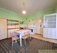 Küche in einem Einfamilienhaus mit Esstisch, Sessel und traditionellem Möbel.