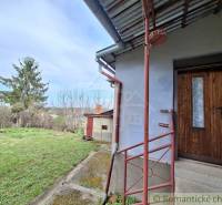 Ein Einfamilienhaus in Ľuba mit einem Rasenhof und Holztüren.