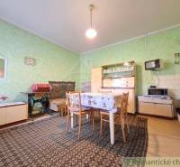 Innenraum eines Einfamilienhauses mit Esstisch, Sessel und Retro-Fernseher.