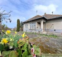 Ein Einfamilienhaus in Ľuba mit einem Blumenbeet und einem gepflasterten Hof.