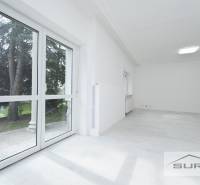 Helles Zimmer mit großen Fenstern und Holzboden in einer 4-Zimmer-Wohnung.