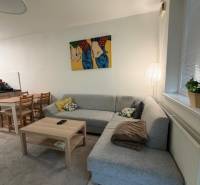Helles Wohnzimmer mit Ecksofa und Kunst in einer 2-Zimmer-Wohnung.