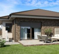 Ein Einfamilienhaus in Veľké Dvorníky mit Terrasse und einem Auto in der Einfahrt.