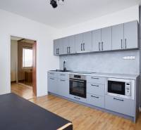 Küche in einer 3-Zimmer-Wohnung mit modernen Geräten und einem Boden in Holzoptik.