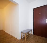 Eingangsbereich mit Holzboden und Bank in einer 3-Zimmer-Wohnung.