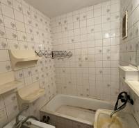 Badezimmer in einer 2-Zimmer-Wohnung mit Badewanne, Waschbecken und Fliesen.