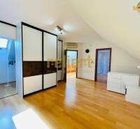 Dachzimmer mit Holzboden und Einbauschrank in einem Einfamilienhaus.