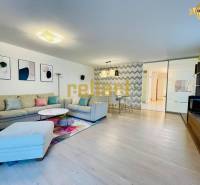 Wohnzimmer in einem Einfamilienhaus mit Sofa, Dekorationen und Holzboden.