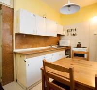 Küche mit Holztisch in einer 3-Zimmer-Wohnung. Schränke, Herd, Kühlschrank mit Magneten.