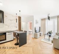Wohnzimmer und Küche in einer 4-Zimmer-Wohnung mit Holzboden und heller Dekoration.