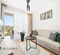 Wohnzimmer in einer 4-Zimmer-Wohnung mit Balkon, Sofa und Boden in Holzoptik.