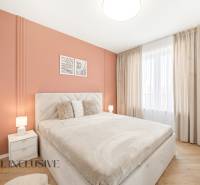 Schlafzimmer mit orangefarbener Wand und Holzboden in einer 4-Zimmer-Wohnung.