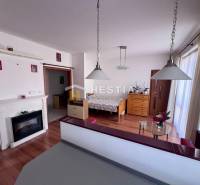 1-Zimmer-Wohnung mit Kamin, Hängeleuchten und Holzmöbeln, ideal zur Vermietung.