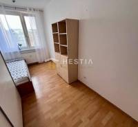 2-Zimmer-Wohnung, Bett am Fenster, Regal, Boden mit Holzdekor, weiße Wand.