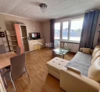 Wohnzimmer in einer 2-Zimmer-Wohnung mit Holzboden, beiges Sofa, Esstisch.