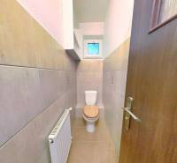 Badezimmer in einem Einfamilienhaus, mit Toilette und Handtuchheizkörper.
