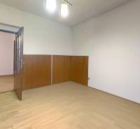 Ein Zimmer in einem Einfamilienhaus mit einem Boden in Holzoptik und Holzverkleidung an den Wänden.