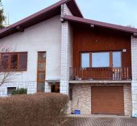 Ein Einfamilienhaus in Vyšná Šebastová mit Balkon, Holzverkleidung und Garage.