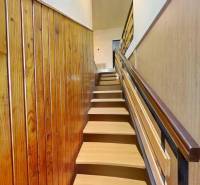 Treppe mit Holzdekor, die in einem Einfamilienhaus in den ersten Stock führt.