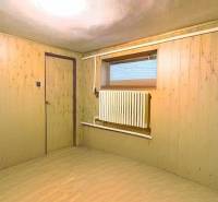 Ein Zimmer mit einem Boden in Holzoptik, Holzwände, Heizkörper, Interieur eines Einfamilienhauses.