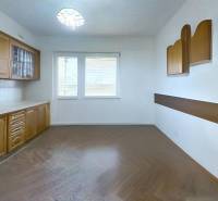 Eine Küche in einem Einfamilienhaus mit hellen Schränken und einem Boden in Holzoptik.