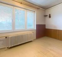 Ein Raum in einem Einfamilienhaus mit einer hellen Wand, einem Fenster und einem Boden mit Holzdekor.