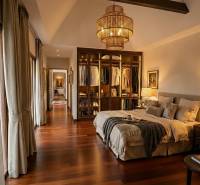 Stilvolles Schlafzimmer in einer Villa mit Holzboden und offenem Kleiderschrank.