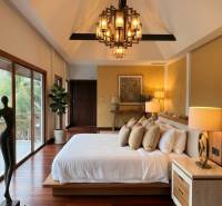 Luxuriöses Schlafzimmer in einer Villa mit Holzboden und großen Fenstern.