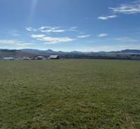Grundstücke - Wohnen in Stránske auf der Straße Borie. Weitläufige grüne Wiese mit Bergkulisse.