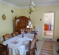 Esszimmer in einem Einfamilienhaus mit Holzmöbeln, Tisch, Stühlen und einer Lampe an der Decke.