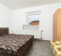 Ein Zimmer in einem Hotel oder einer Pension mit einem einzigartigen Bettmuster und einem Wandbild.