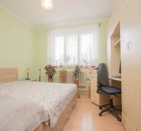 Schlafzimmer in einem Einfamilienhaus mit Holzboden, Bett und Schreibtisch.