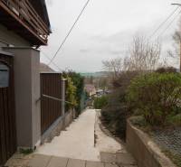 Zugangspfad zu einem Einfamilienhaus in Kostoľany nad Hornádom, umgeben von einem Holzzaun.