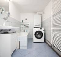 Badezimmer in einem Einfamilienhaus mit Badewanne, Waschbecken, Waschmaschine und Handtuchheizkörper.