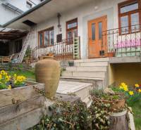 Ein Einfamilienhaus in Kostoľany nad Hornádom mit Blumen, einer Terrasse und Treppen zum Garten.