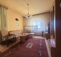 Wohnzimmer in einem Einfamilienhaus mit einem bequemen Sofa und einem Boden in Holzoptik.